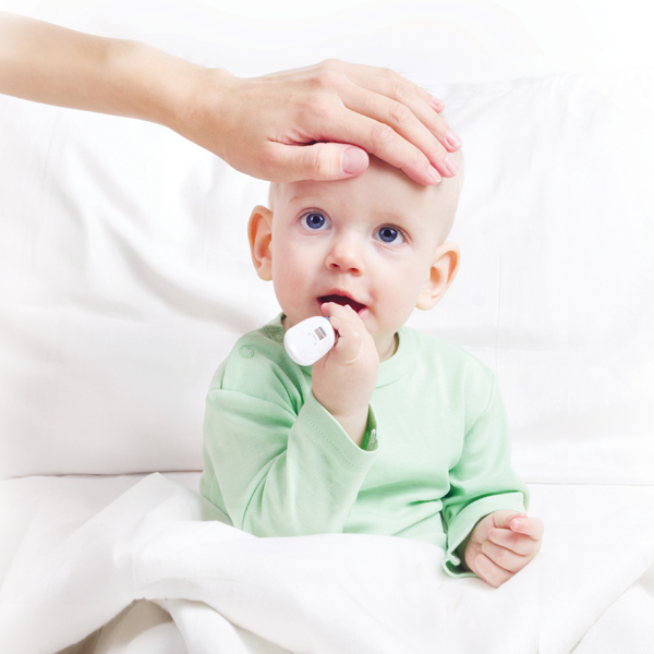 Hand on the forehead of toddler with thermometer